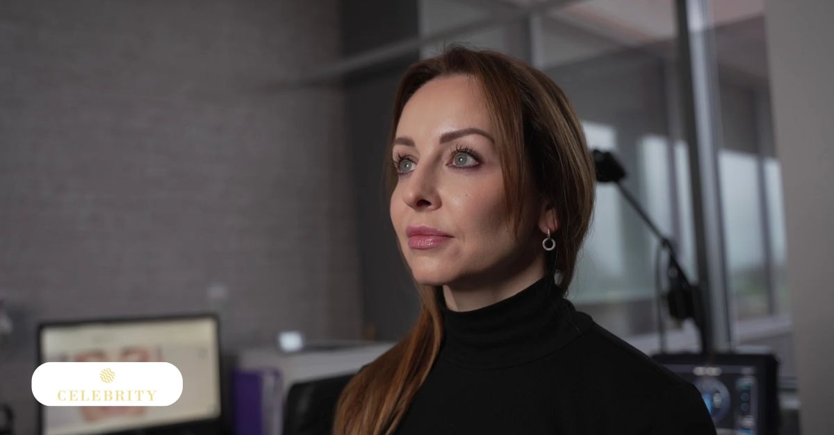 Close-up portrait of a middle-aged woman with auburn hair in black turtleneck, looking thoughtfully to the side in a modern clinic.
