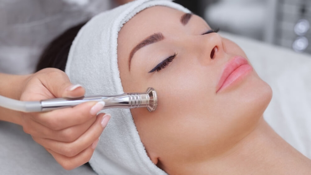 The cosmetologist makes the procedure microdermabrasion of the facial skin