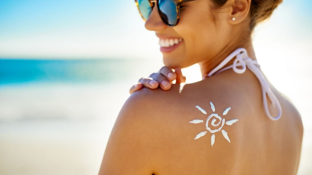 A woman uses sunscreen to protect her skin from sunlight
