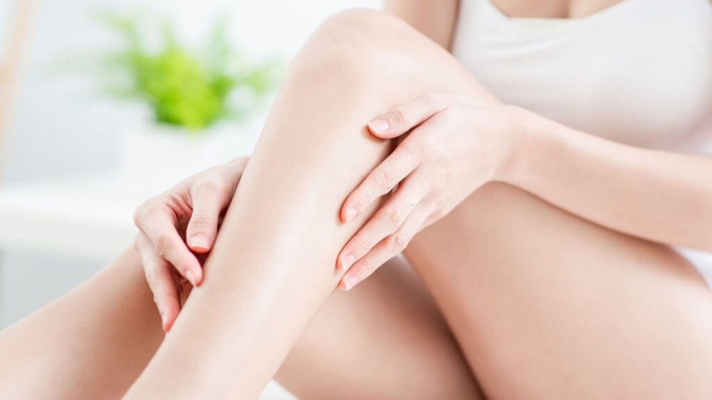 Woman touching shaved legs with laser hair removal