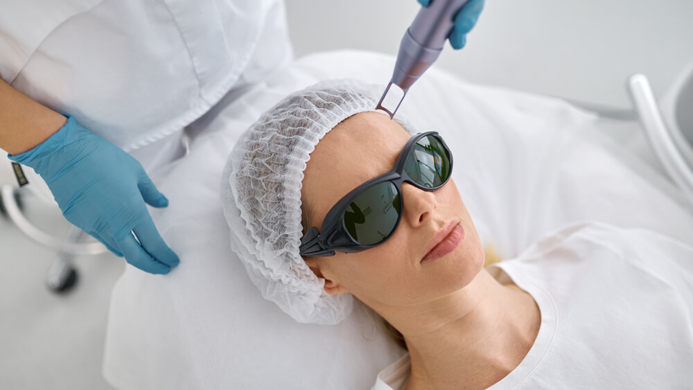 Cosmetologist preparing client for facial laser