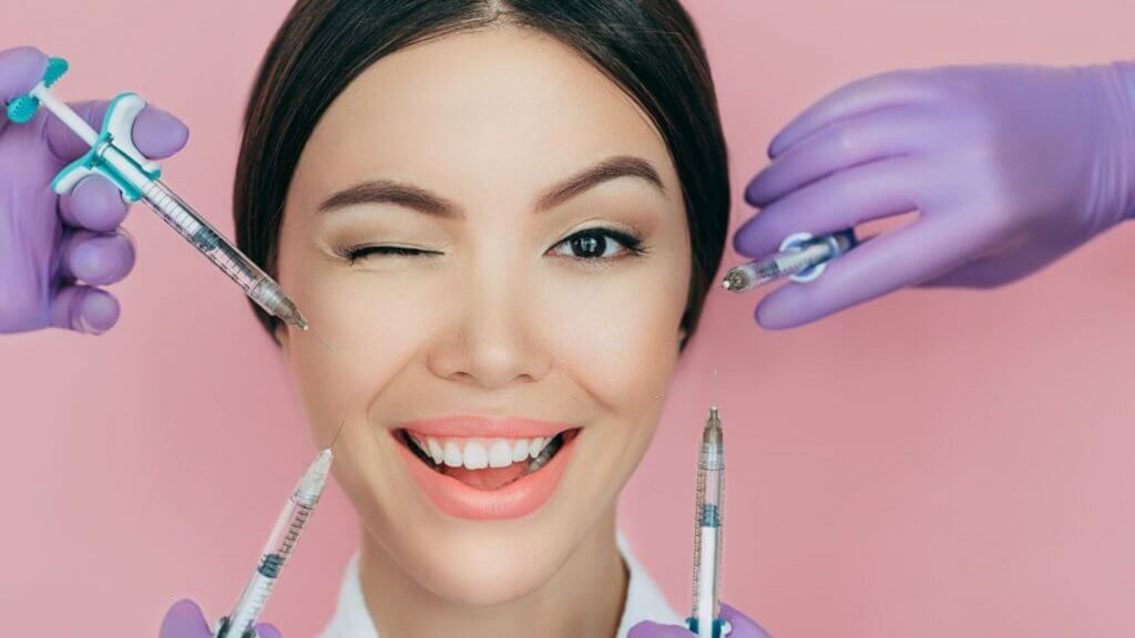 Beautiful winking woman and many syringes for beauty injections