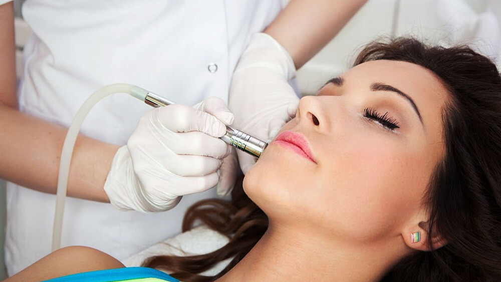 Woman getting microneedling treatment in medical spa center