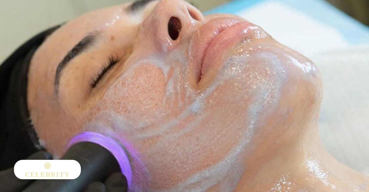 A technician using an OxyGeneo device to exfoliate and oxygenate a client’s facial skin.