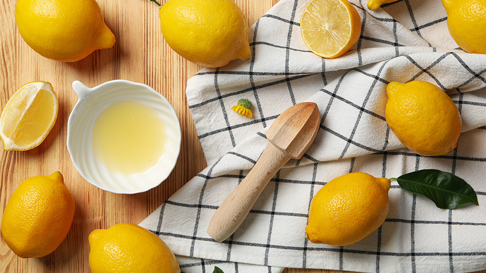 Lemon slices with wooden juicer on the table