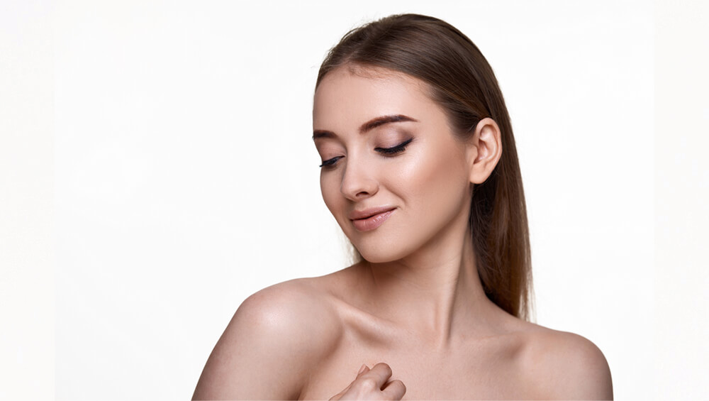 Woman touching her shoulder and enjoying her perfect skin