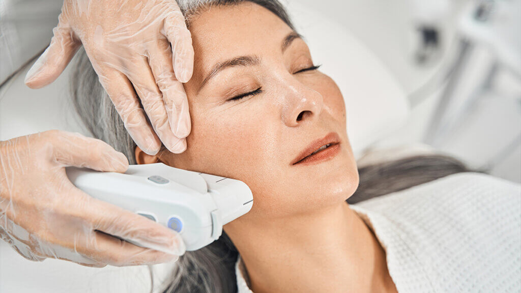 Asian patient enjoying laser treatment procedure on her face