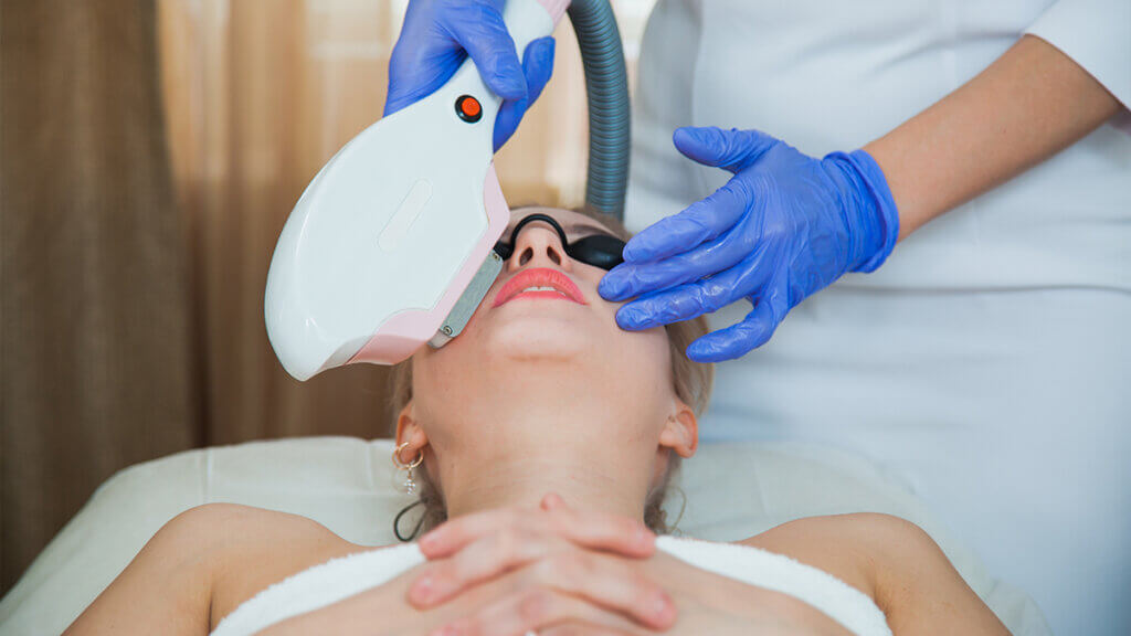 Laser treatment on woman's face skin