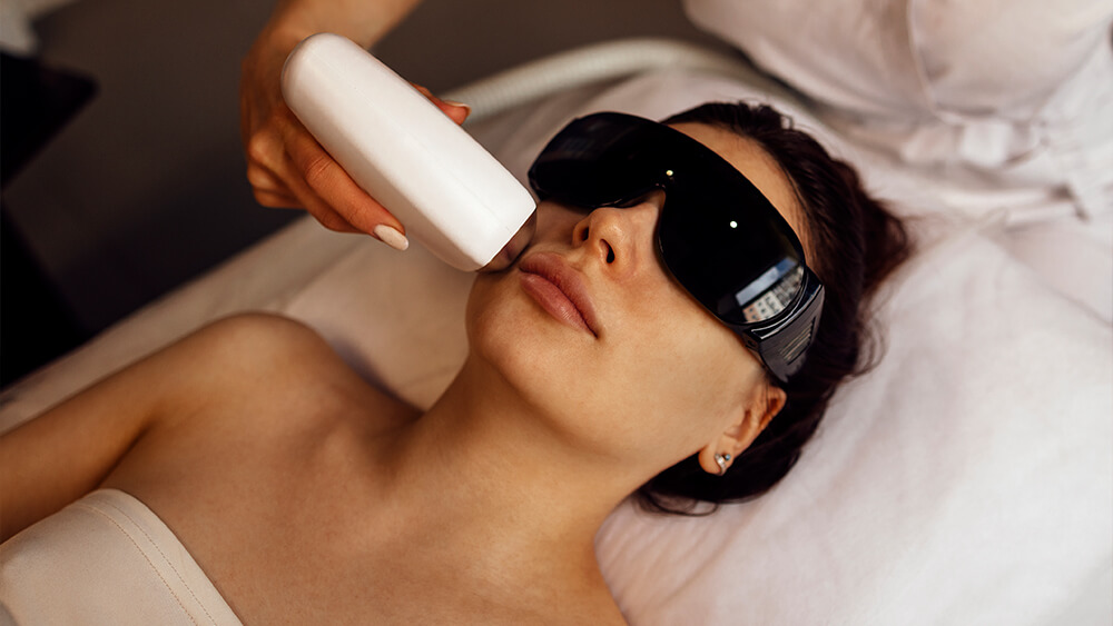 Young woman receiving laser treatment on her face