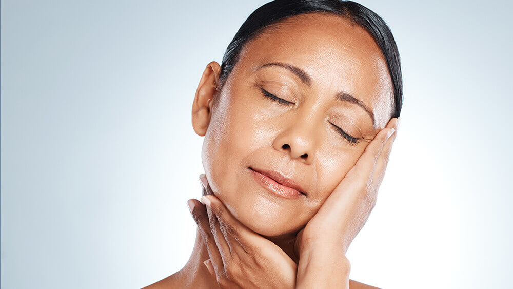 Senior black woman touching her face