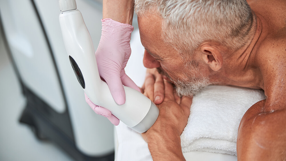 Senior man under laser hair removal treatment