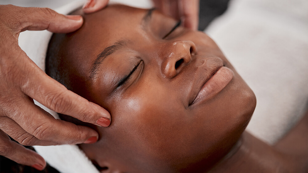 Black woman under spa massage on her face