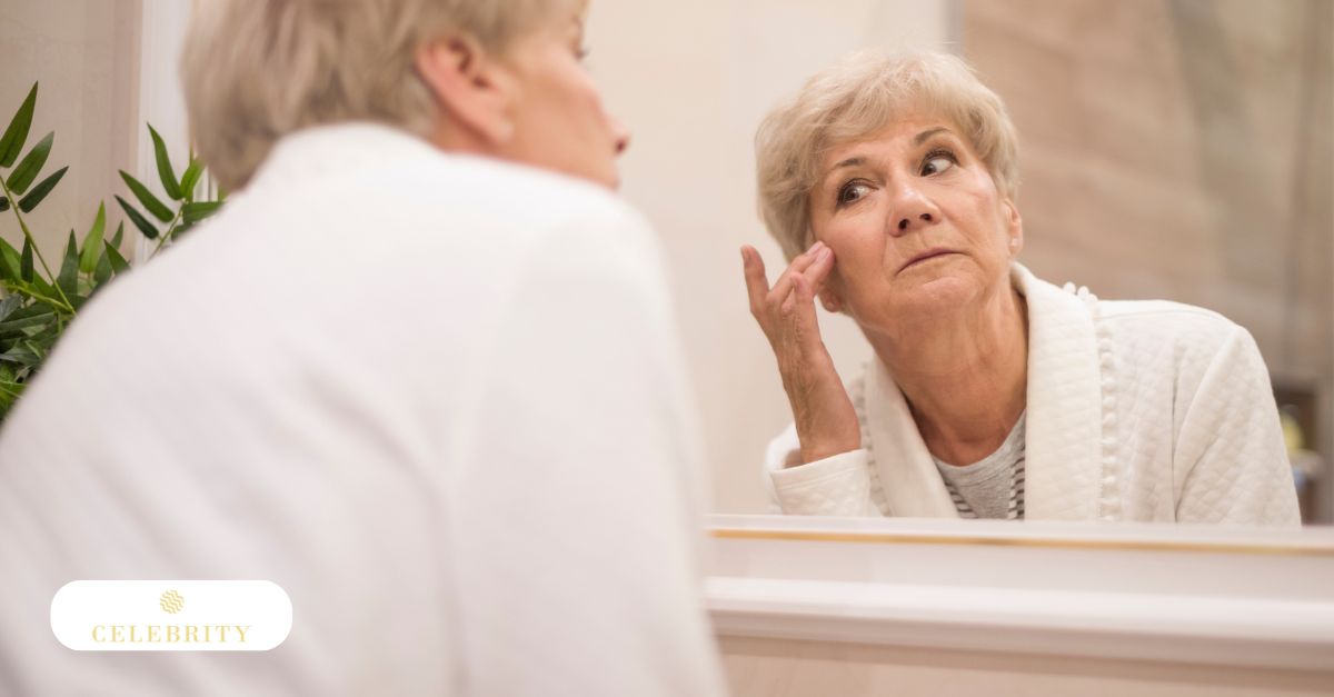 Older woman examining facial wrinkles in mirror, noticing early signs of aging and skin sagging.